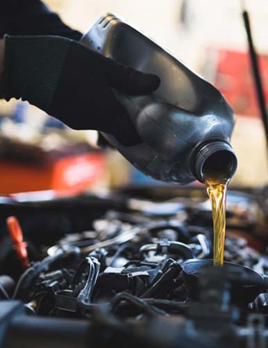 Mechanic adding oil to car